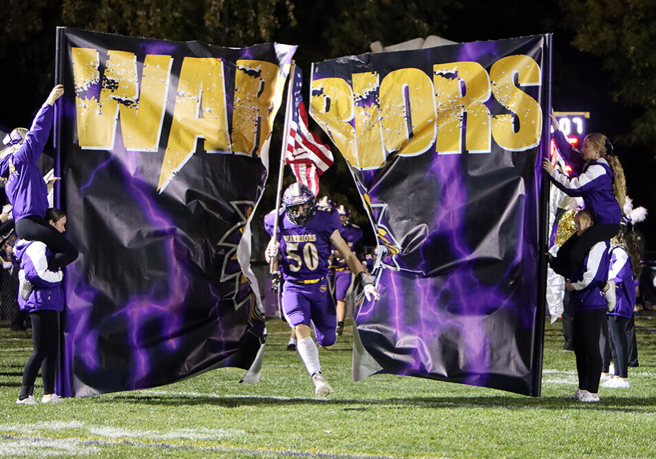 Defensive standout Fred Thomas leads the Warriors onto Sinclair-Vidoni Field Saturday night. Thomas finished the game with six tackles and a sack in the 35-0 playoff victory.